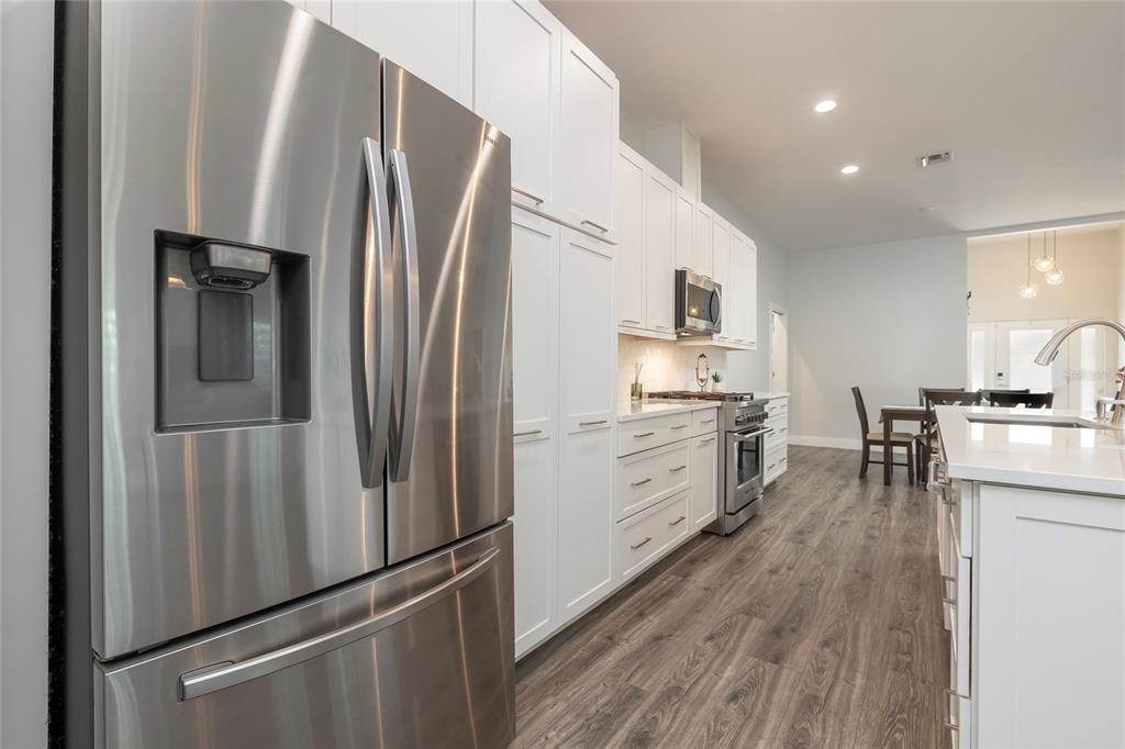 416 Indiana Avenue Crystal Beach, FL 34683 - Photo 9 of 60 a kitchen with stainless steel appliances a refrigerator sink and stove