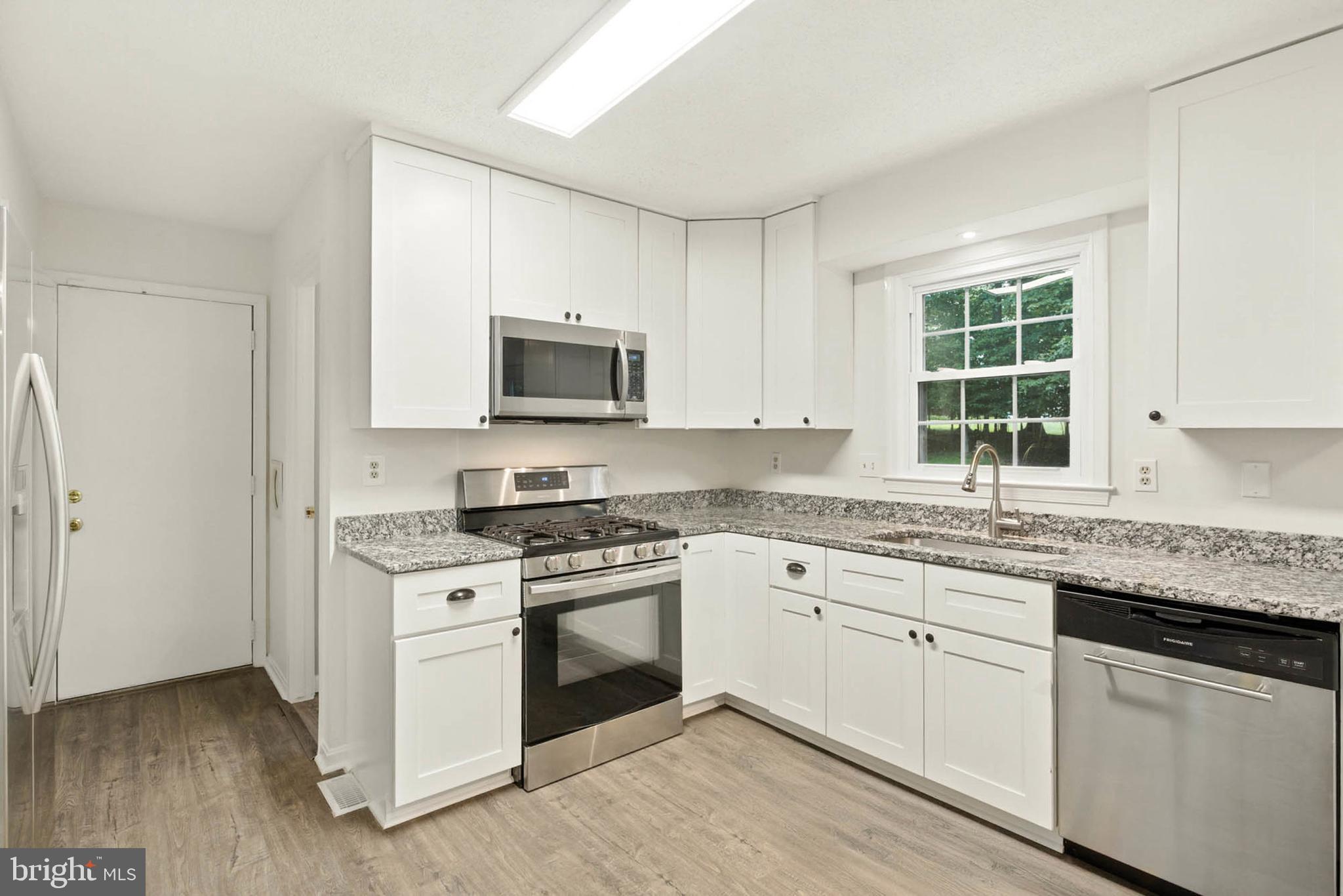 2605 Bainbridge Lane Silver Spring, MD 20906 - Photo 11 of 33 a kitchen with granite countertop white cabinets and a stove