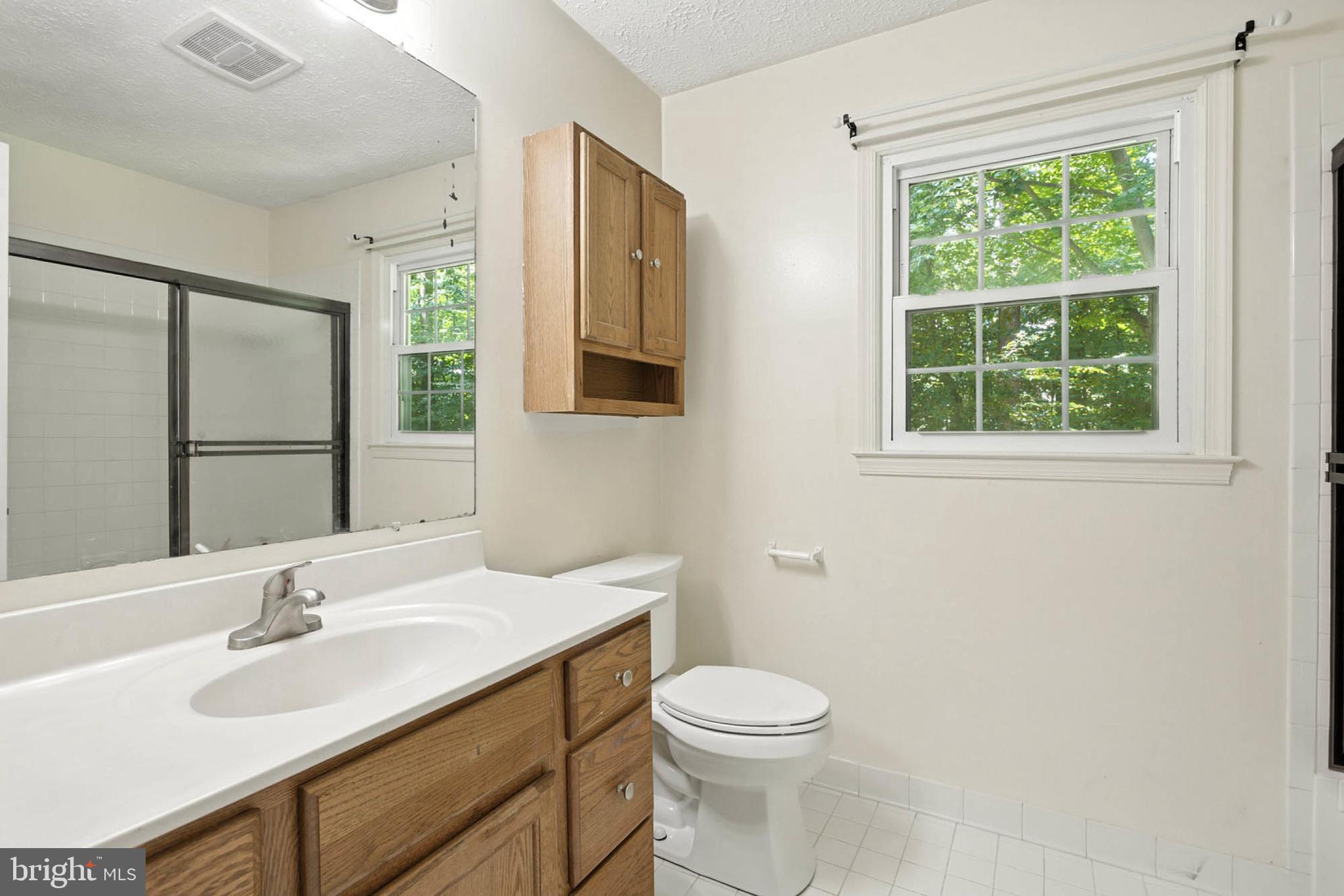 2605 Bainbridge Lane Silver Spring, MD 20906 - Photo 29 of 33 a bathroom with a double vanity sink toilet and a mirror