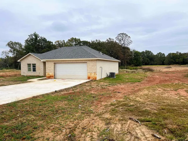 a front view of a house with a garden and yard