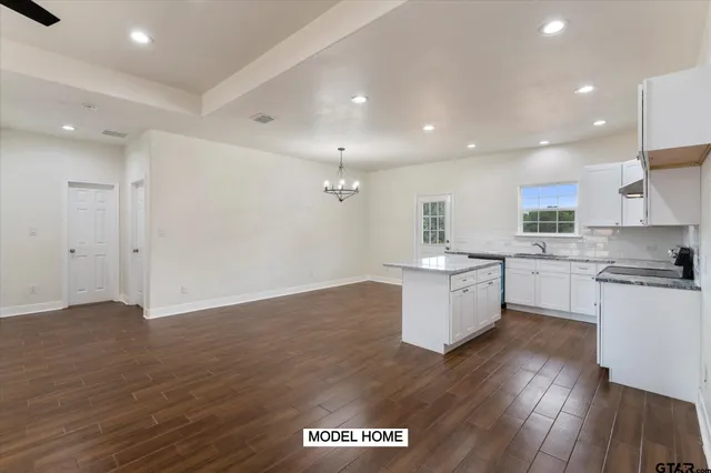 a kitchen with a refrigerator and white cabinets
