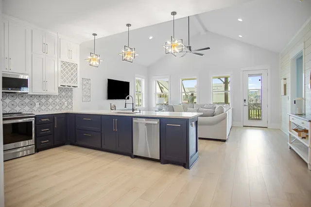 a large kitchen with a large counter space a sink stainless steel appliances and cabinets