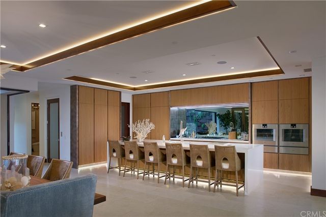 a living room with furniture a chandelier and a floor to ceiling window