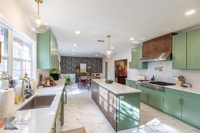 a kitchen with stainless steel appliances kitchen island granite countertop a sink and cabinets