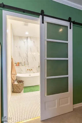 a bathroom with a window bathtub and door