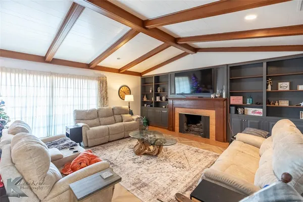 a living room with furniture a fireplace and a flat screen tv