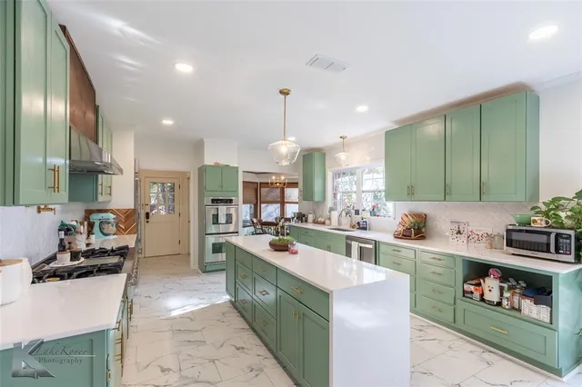 a large kitchen with a large counter top appliances and cabinets