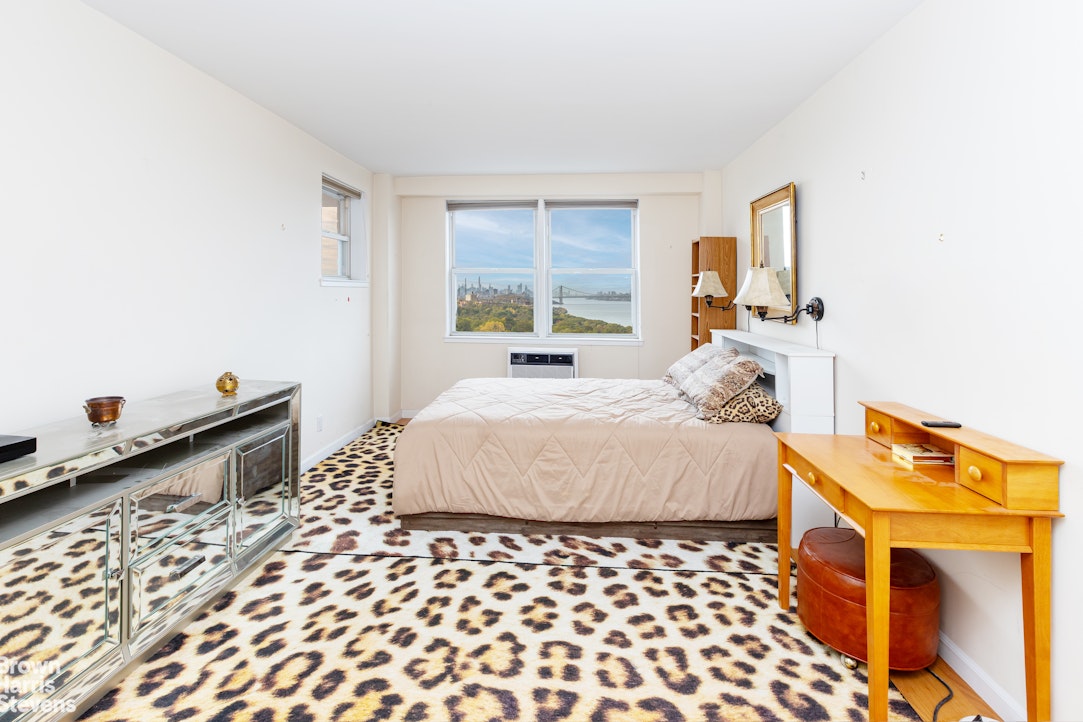 5700 Arlington Avenue, Unit 20S Bronx, NY 10471 - Photo 2 of 15 a bedroom with a bed and wooden floor