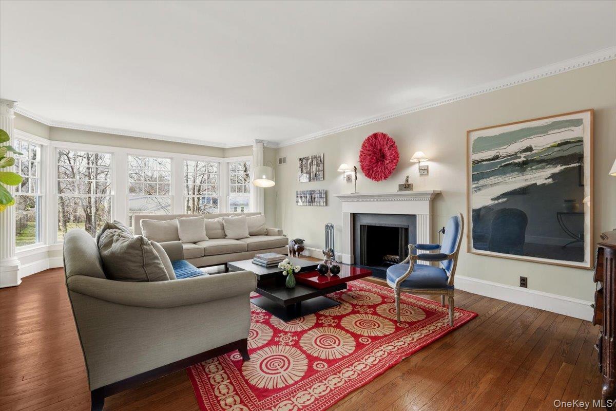 8 Douglas Circle Rye, NY 10580 - Photo 5 of 36 The living room's bay window brings light to a cozy space anchored by a wood-burning fireplace.