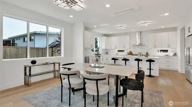 a kitchen with stainless steel appliances kitchen island granite countertop a stove a sink a dining table and chairs