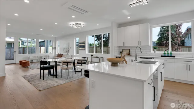 a large kitchen with lots of counter space a sink dining table and chairs
