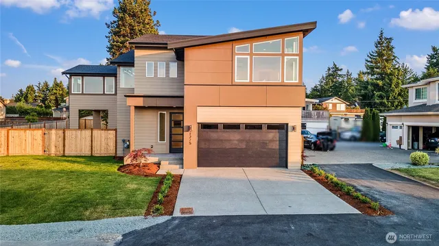 a front view of a house with a yard and a garage