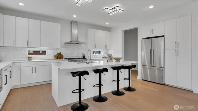 a kitchen with stainless steel appliances granite countertop a stove a refrigerator and white cabinets