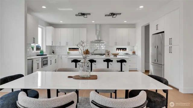 a kitchen with kitchen island a dining table and chairs