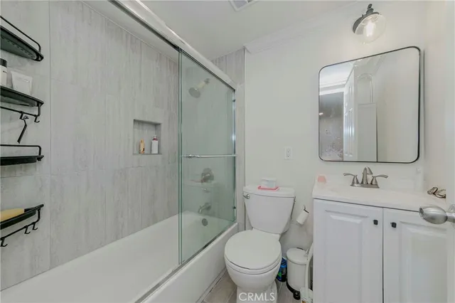 a bathroom with a toilet sink vanity tub and shower