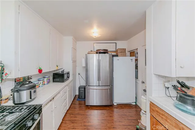 a kitchen with granite countertop a refrigerator and a sink
