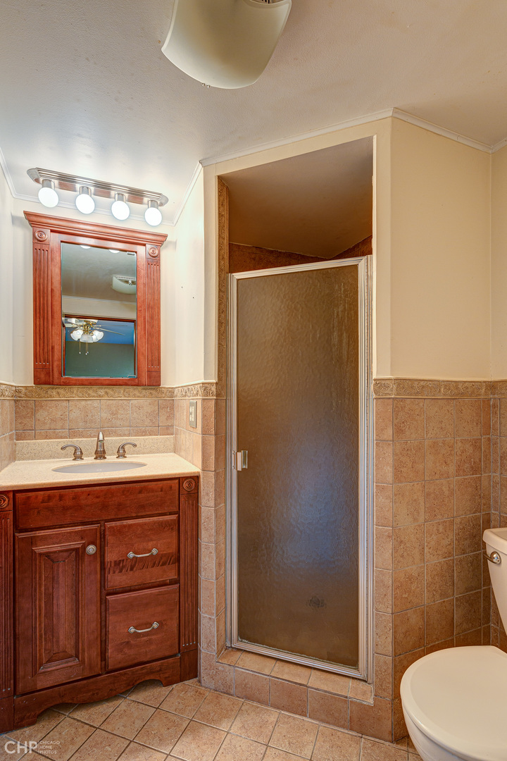3027 Red Barn Road Crystal Lake, IL 60012 - Photo 22 of 40 a bathroom with a toilet a sink a mirror a vanity and shower