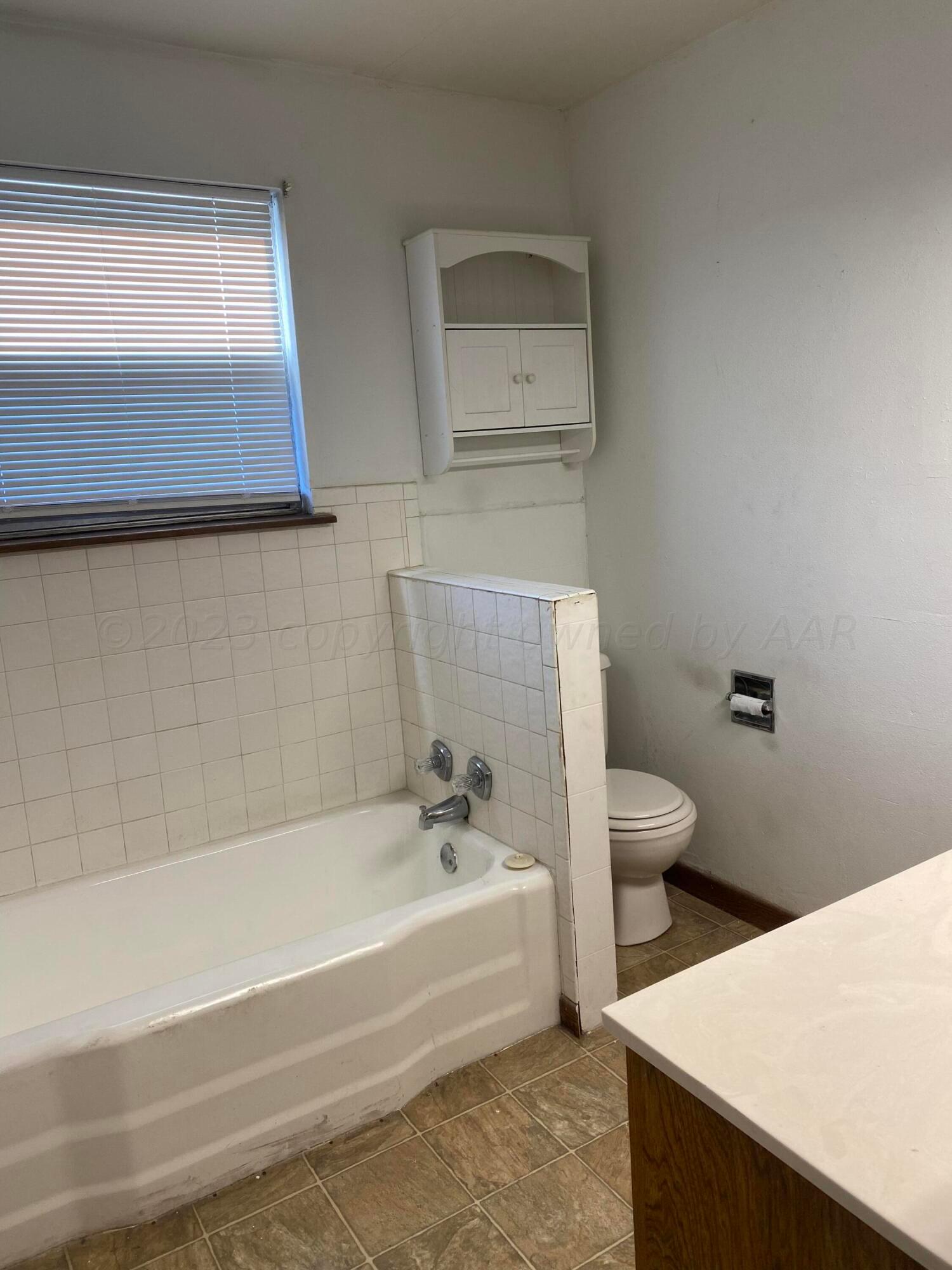 310 Santa Fe Street Borger, TX 79007 - Photo 11 of 18 a bathroom with a bathtub and sink