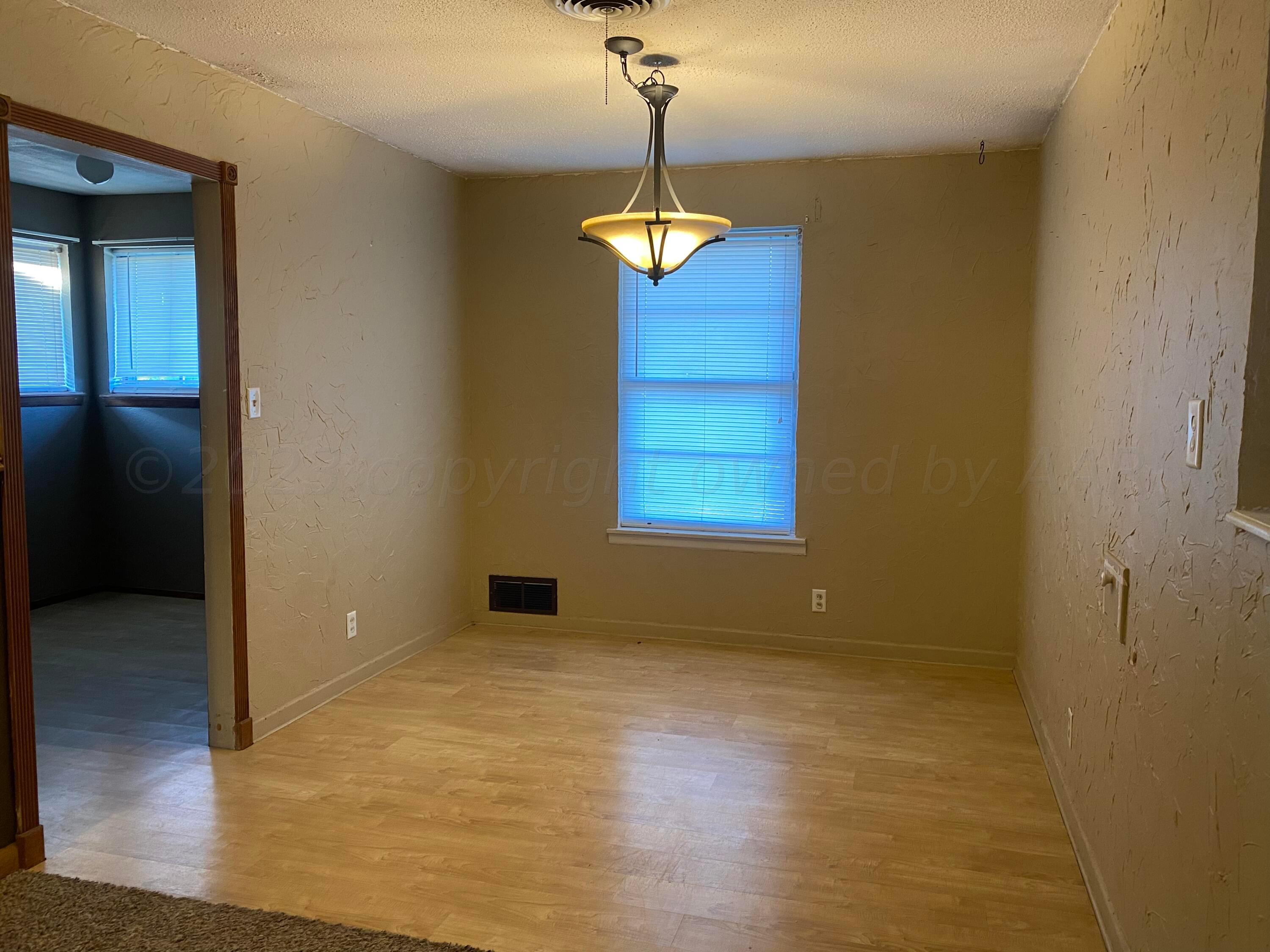 310 Santa Fe Street Borger, TX 79007 - Photo 4 of 18 wooden floor in an empty room with a window