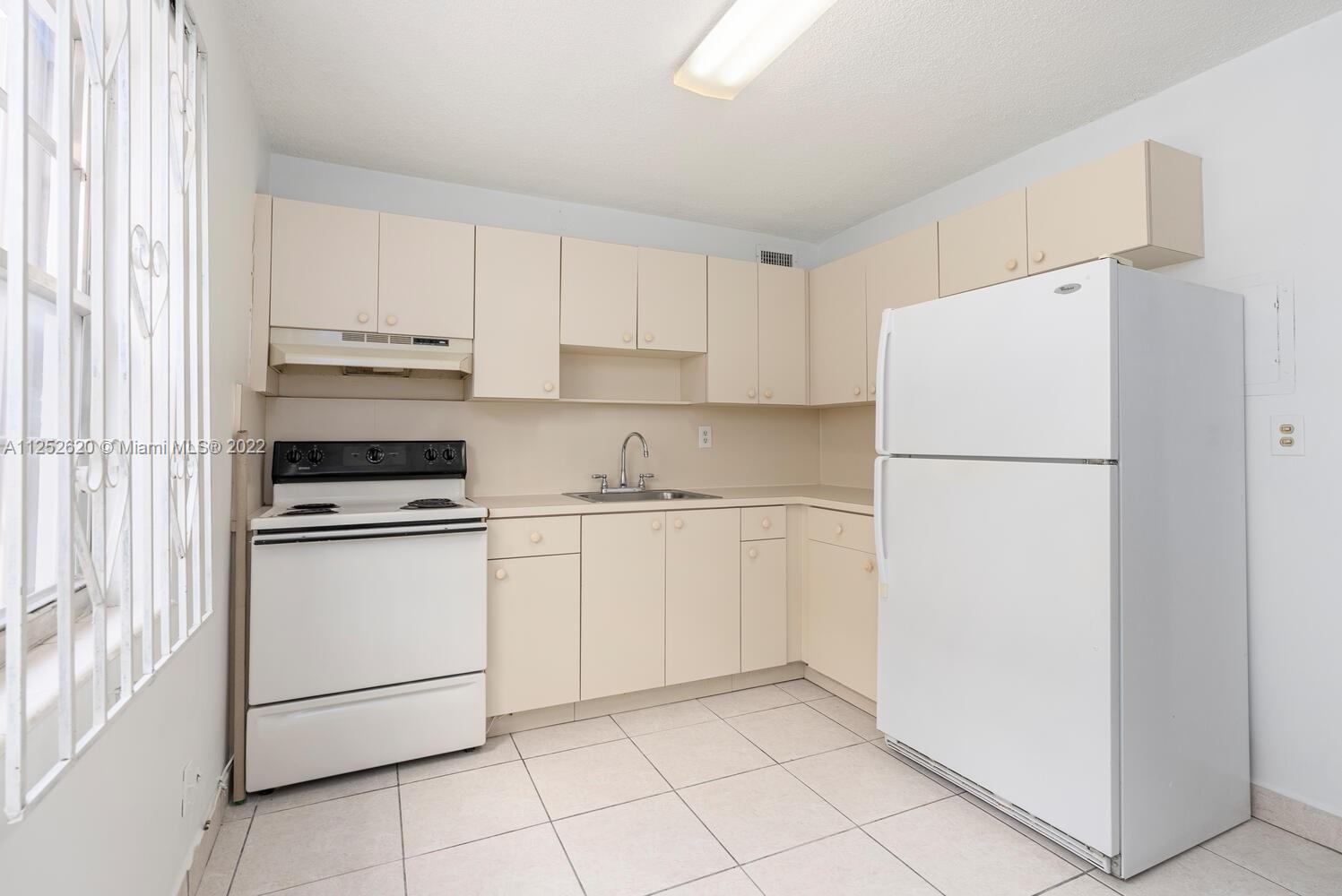 1390 Northwest 2nd Street, Unit 2 Miami, FL 33125 - Photo 6 of 10 a kitchen with a refrigerator sink stove and cabinets