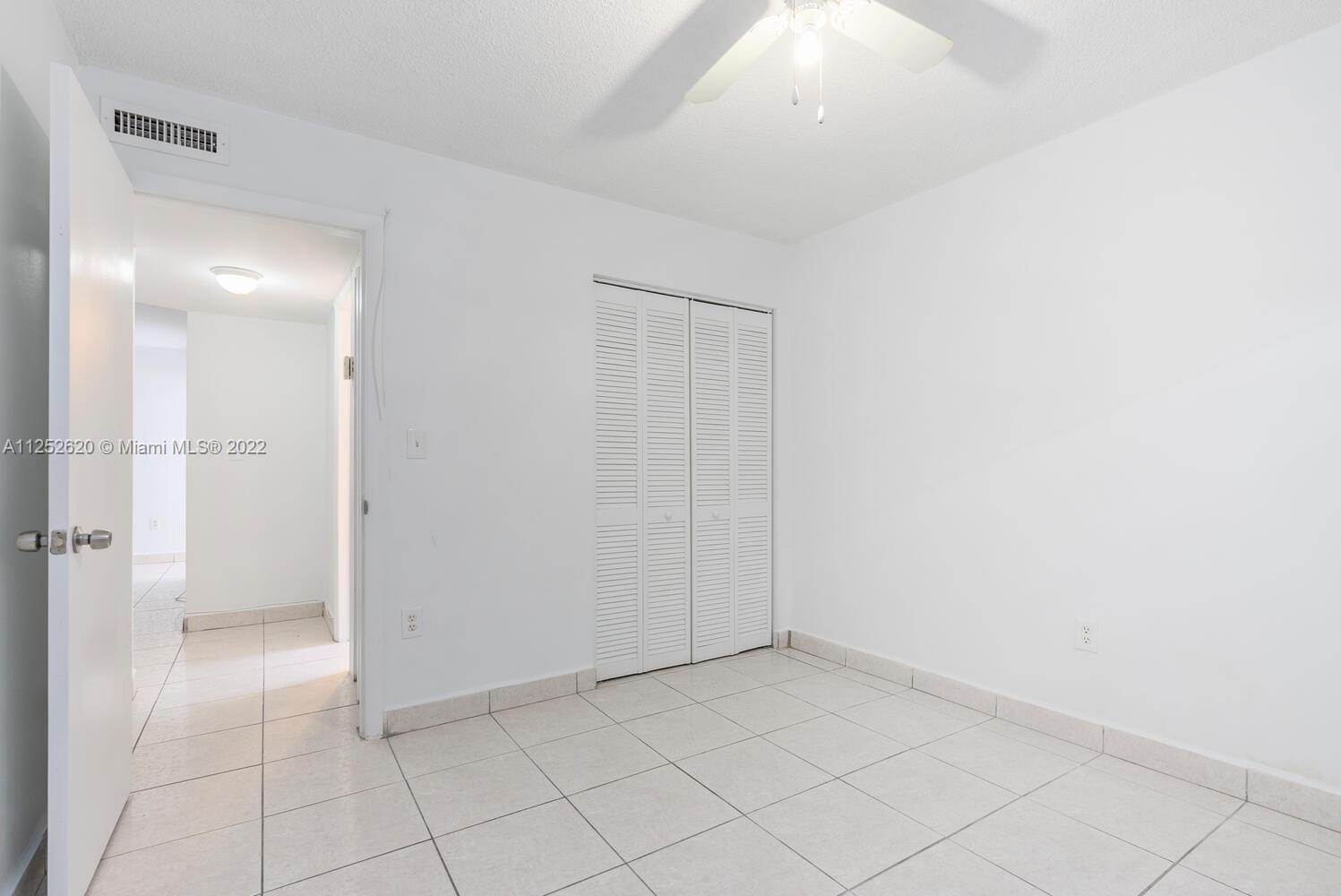 1390 Northwest 2nd Street, Unit 2 Miami, FL 33125 - Photo 9 of 10 an empty room with white cabinet and mirrors