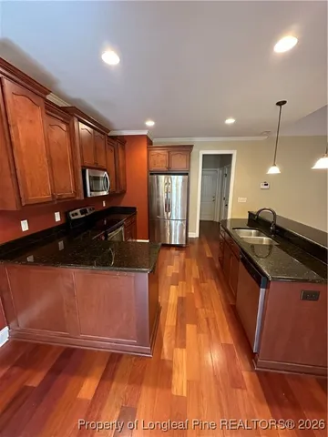 a large kitchen with stainless steel appliances a large counter top a stove a chimney a sink and a large window