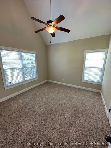 an empty room with windows and fan