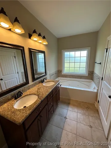 a spacious bathroom with a granite countertop tub sink and mirror