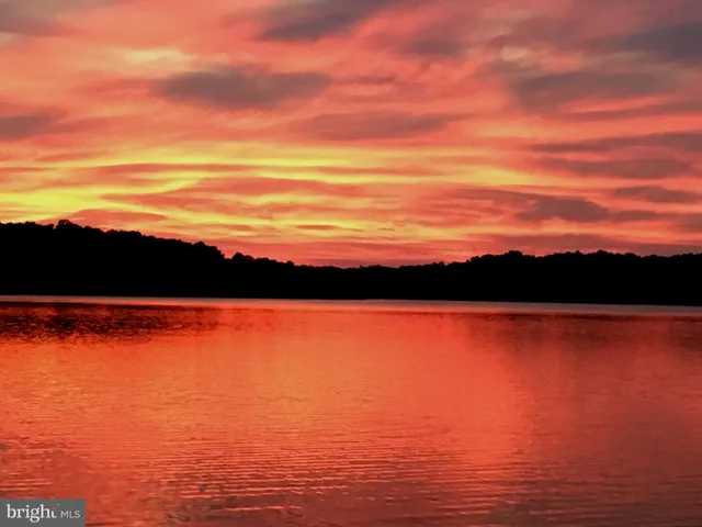 a view of a dining room and livingroom with furniture wooden floor a chandelier