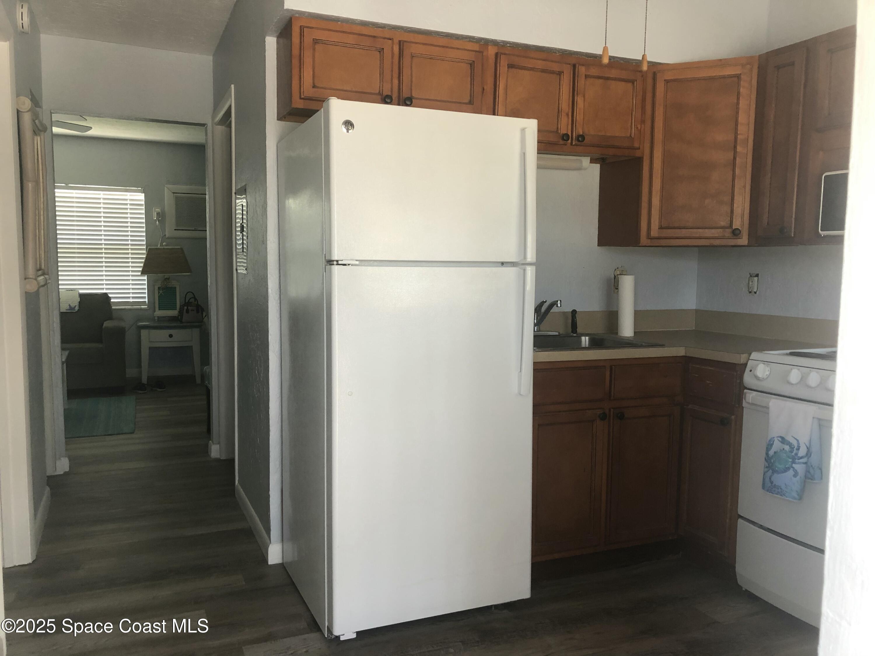 380 North Brevard Avenue, Unit C7 Cocoa Beach, FL 32931 - Photo 6 of 10 a white refrigerator freezer and a stove sitting inside of a kitchen