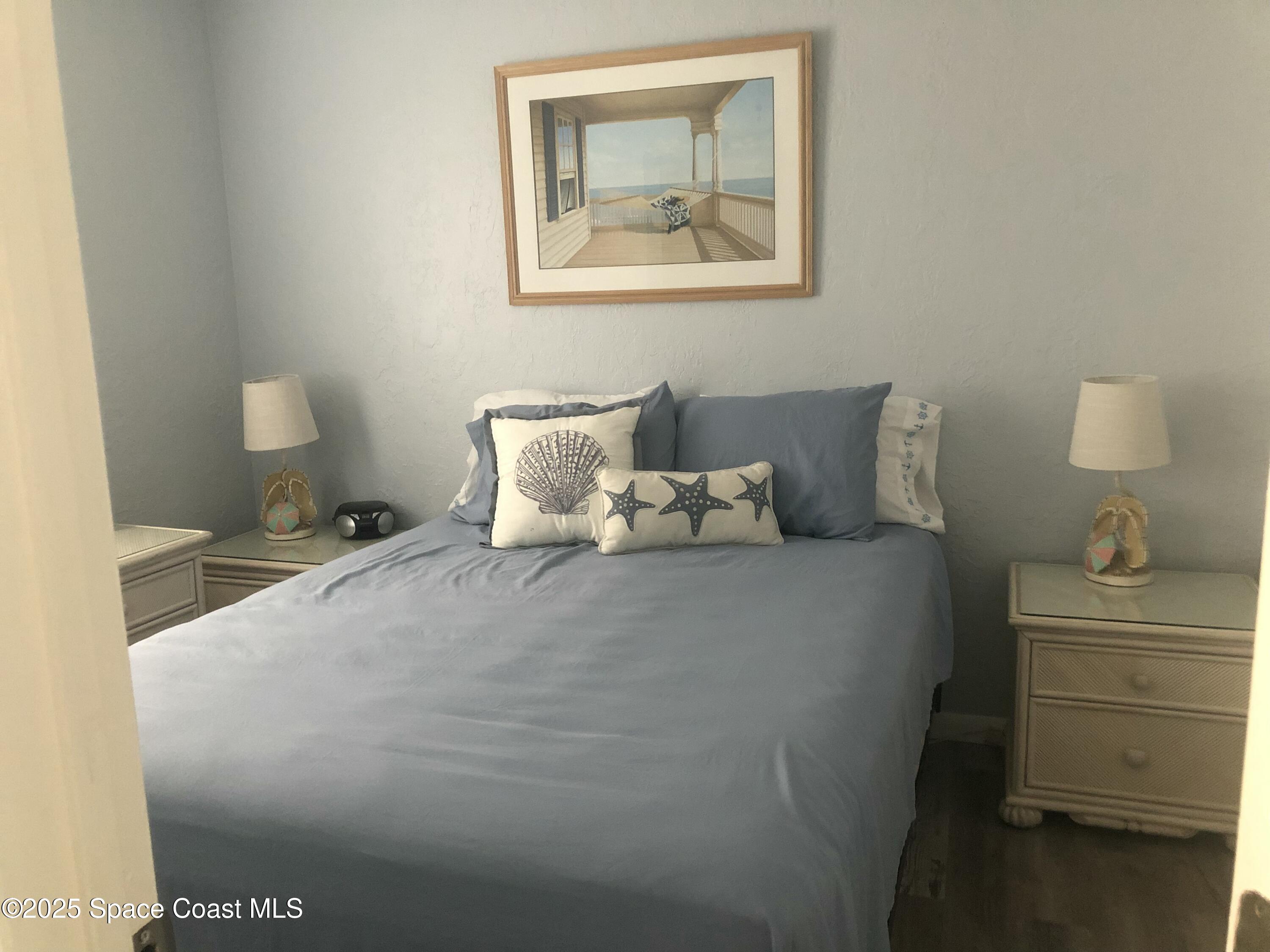 380 North Brevard Avenue, Unit C7 Cocoa Beach, FL 32931 - Photo 7 of 10 a bedroom with a bed and cabinet