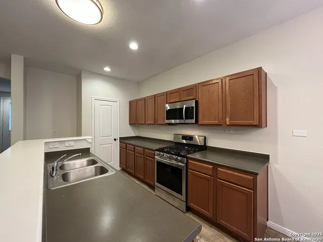 a kitchen with stainless steel appliances granite countertop a stove a sink and a microwave