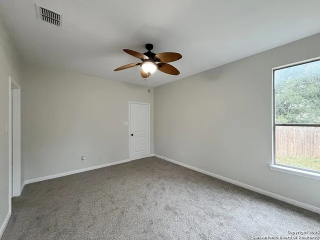 a view of room with a ceiling fan and window