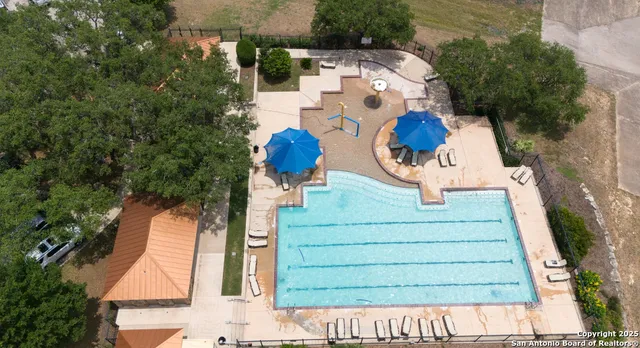 an aerial view of residential houses with outdoor space and trees