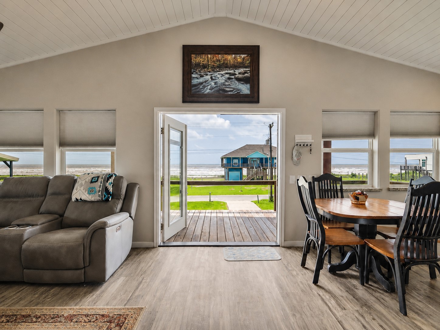 1453 County Road 230 Sargent, TX 77414 - Photo 8 of 38 This inviting living space features large windows and a glass door offers stunning views of the ocean, enhancing the bright and airy feel. Perfect for enjoying beach sounds and living.