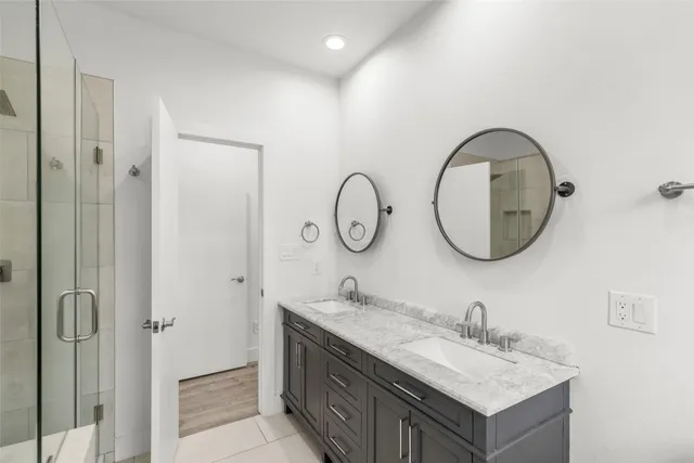 a bathroom with a granite countertop double vanity sink and a mirror