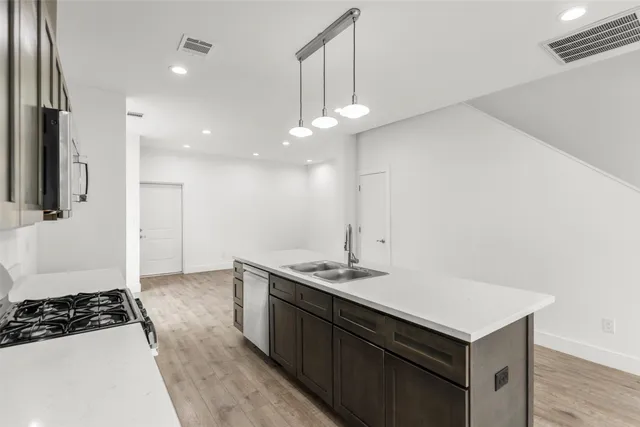 a kitchen with a sink a stove a refrigerator and cabinets