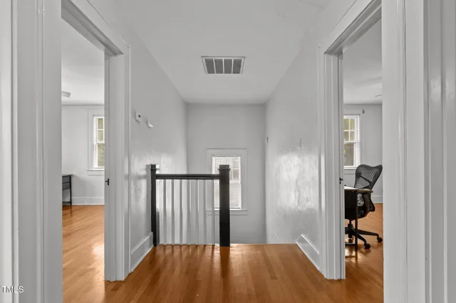a view of a hallway with wooden floor and entryway