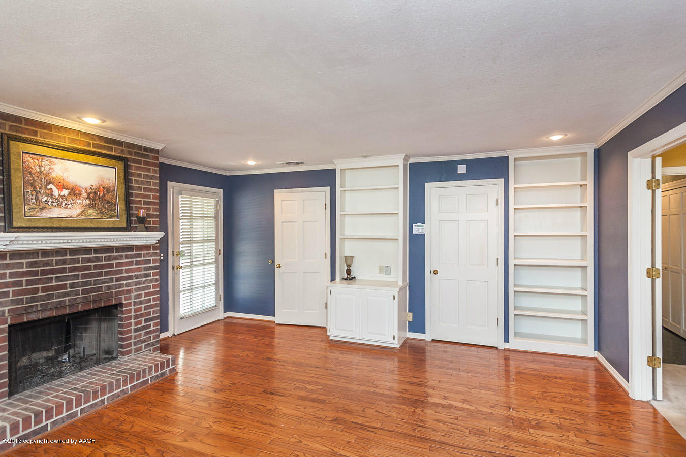 6707 Jameson Road Amarillo, TX 79106 - Photo 8 of 28 an empty room with wooden floor fireplace and windows