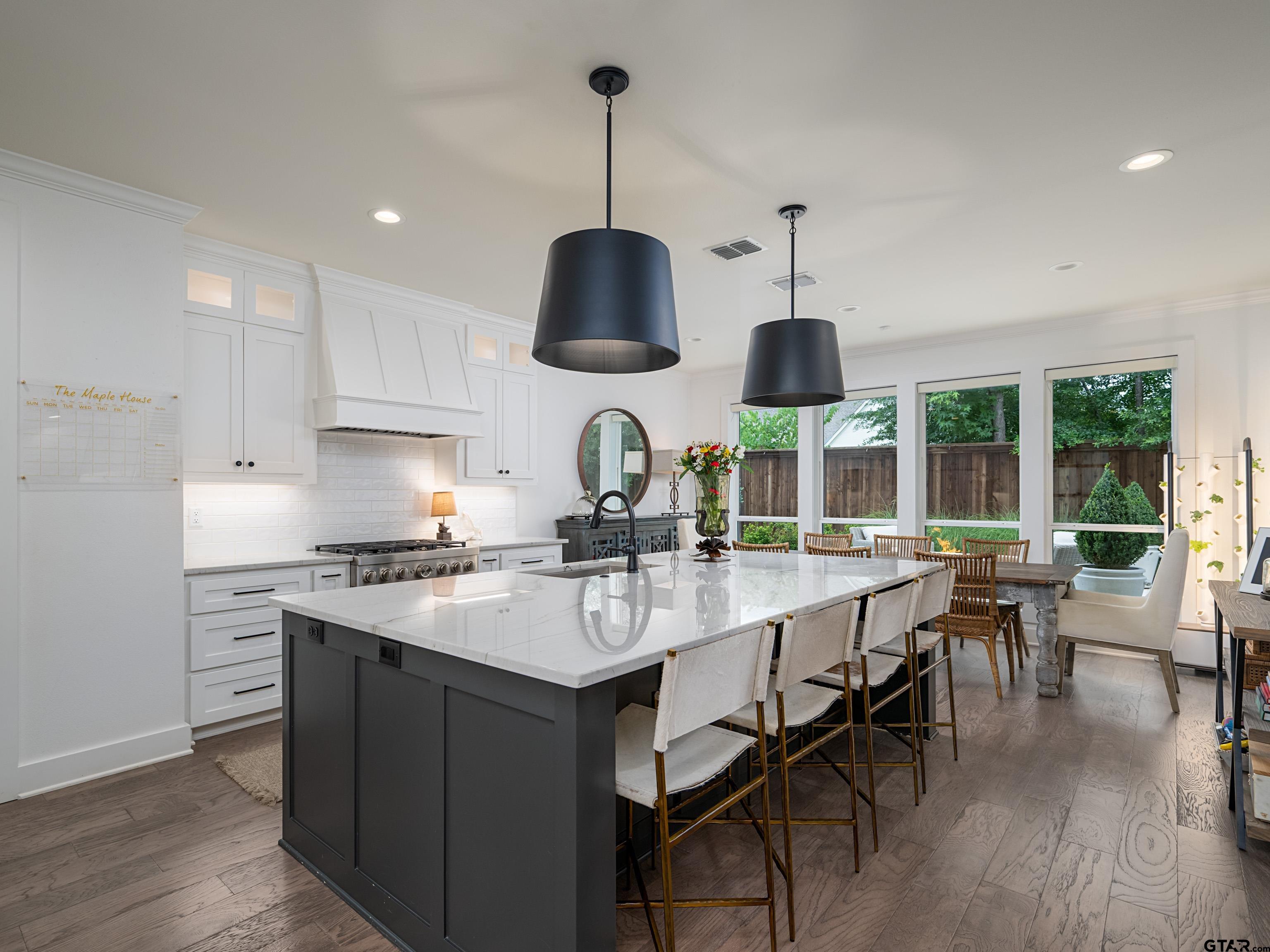 1555 Maple Lane Tyler, TX 75703 - Photo 11 of 43 a kitchen with stainless steel appliances a stove a sink a dining table and chairs