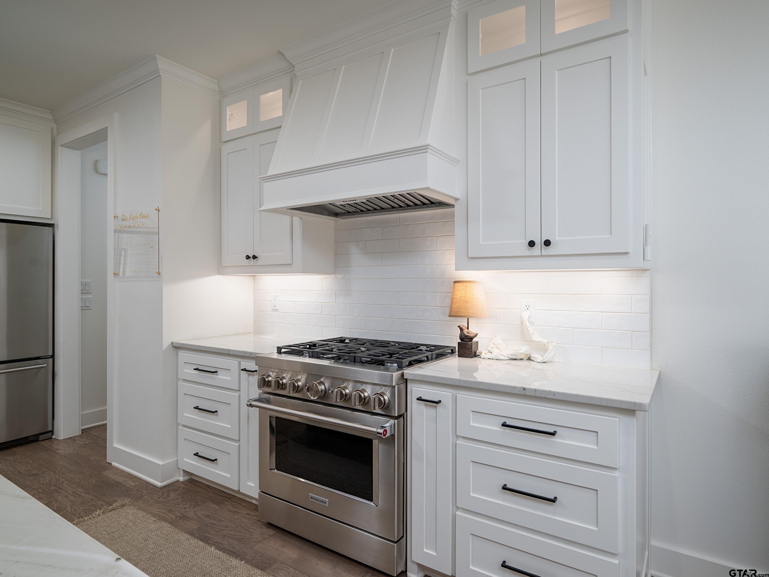 1555 Maple Lane Tyler, TX 75703 - Photo 14 of 43 a kitchen with white cabinets and a stove with a sink