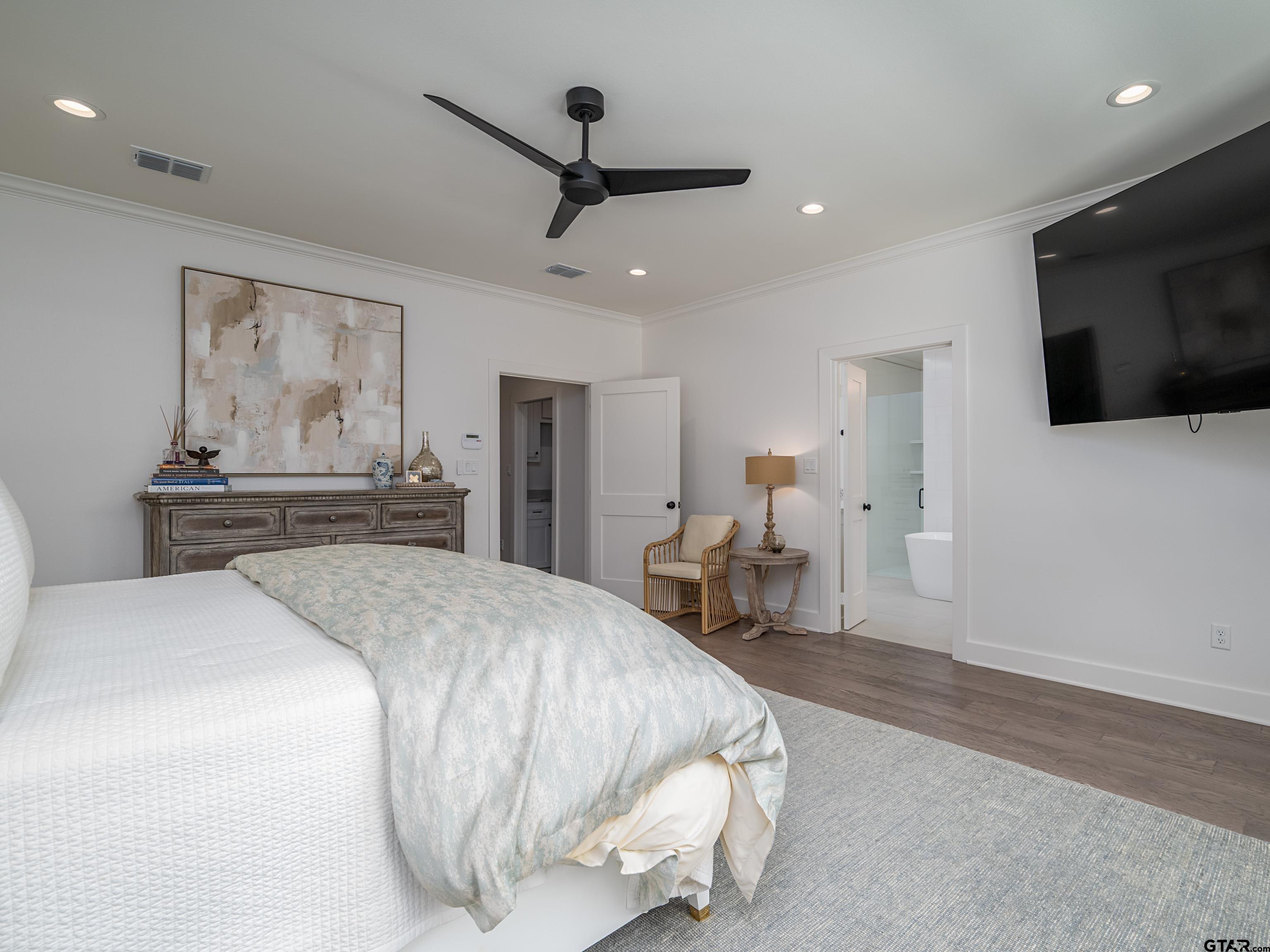 1555 Maple Lane Tyler, TX 75703 - Photo 19 of 43 a spacious bedroom with a bed and a flat screen tv