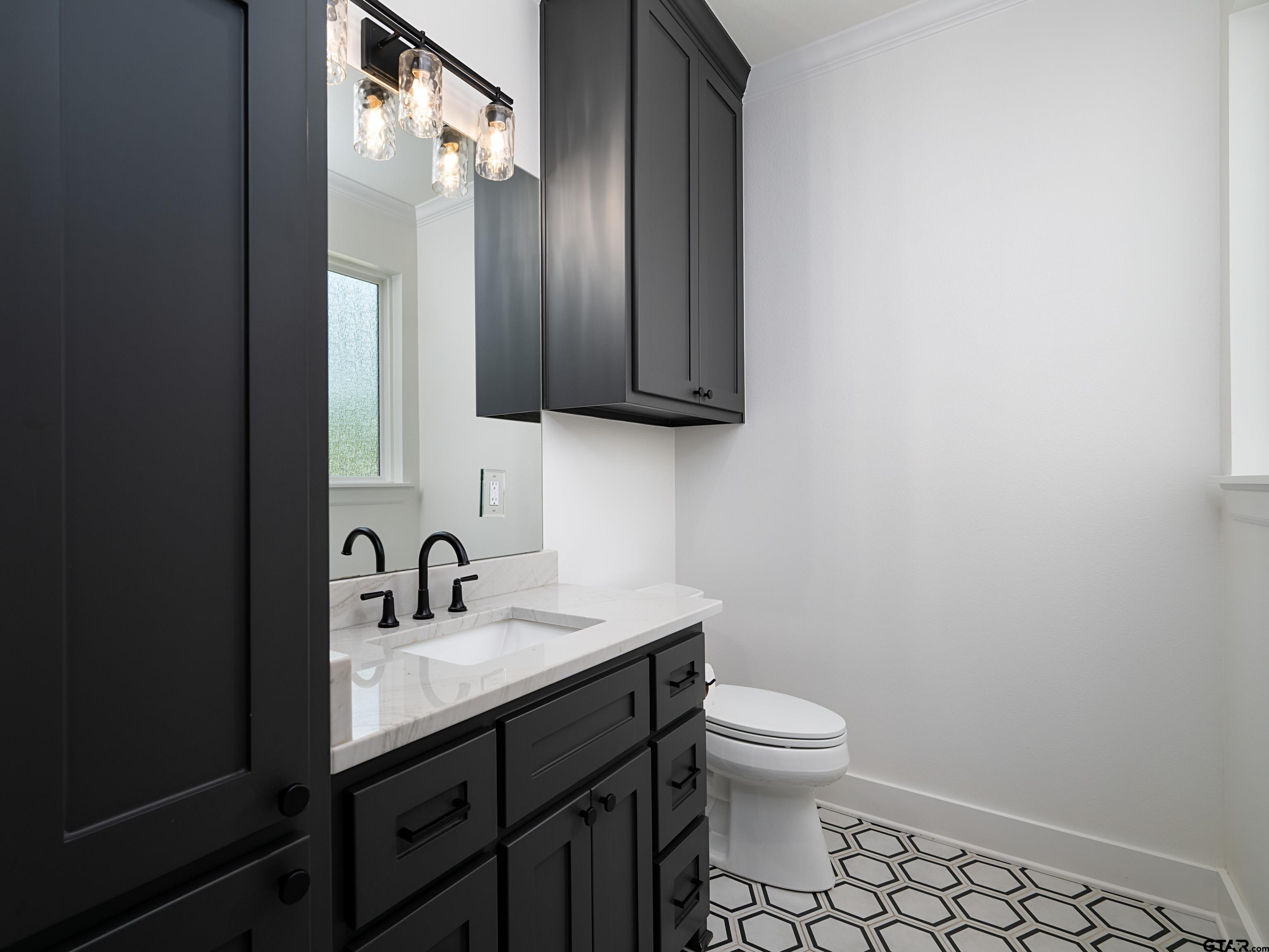 1555 Maple Lane Tyler, TX 75703 - Photo 26 of 43 a bathroom with a toilet a sink and mirror