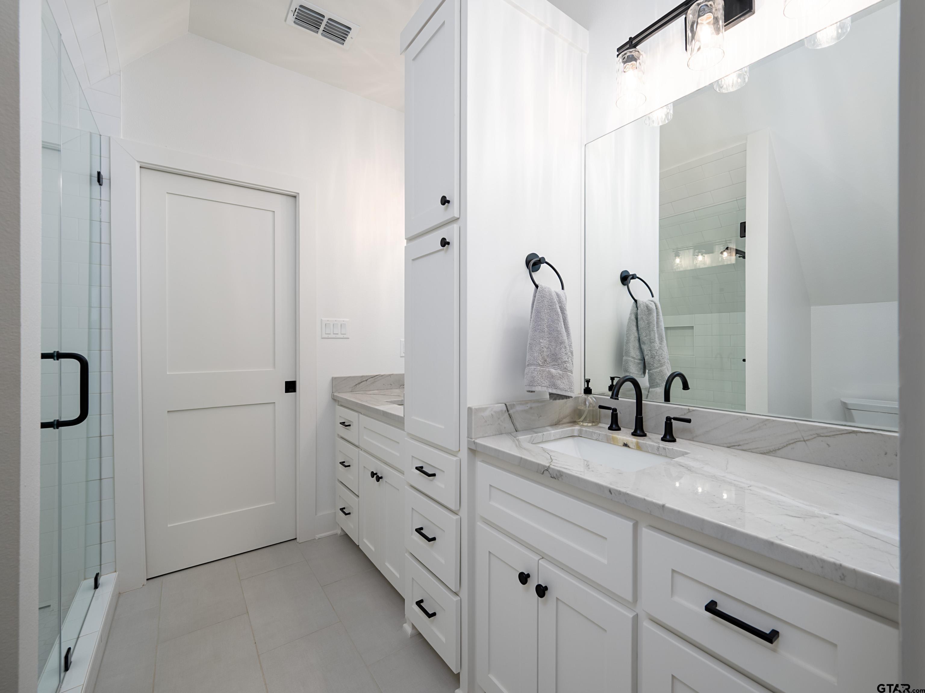 1555 Maple Lane Tyler, TX 75703 - Photo 29 of 43 a bathroom with a double vanity sink and mirror