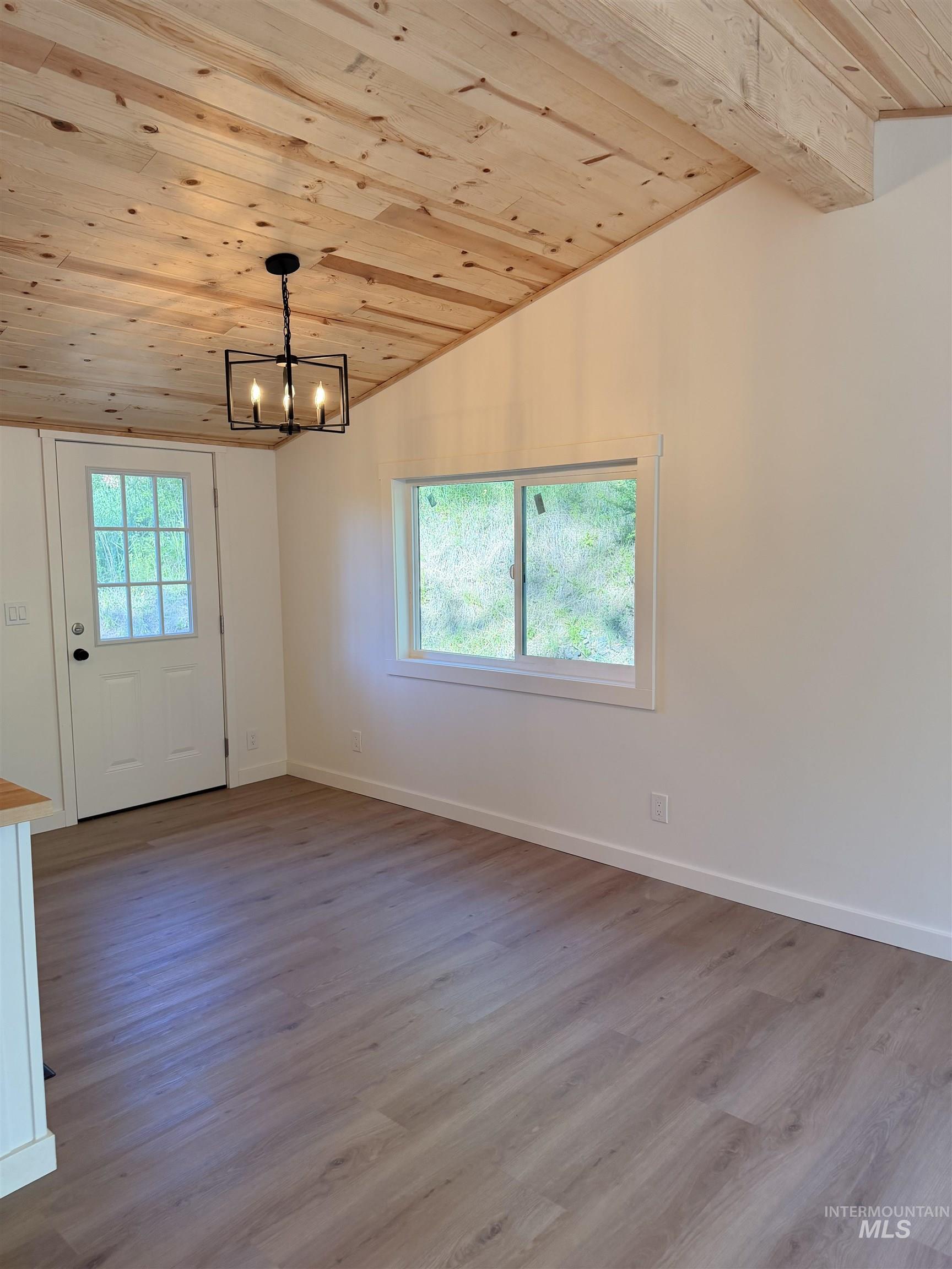 151 View Road Kamiah, ID 83536 - Photo 12 of 49 Vaulted wood-plank ceiling with exposed beam and modern black chandelier