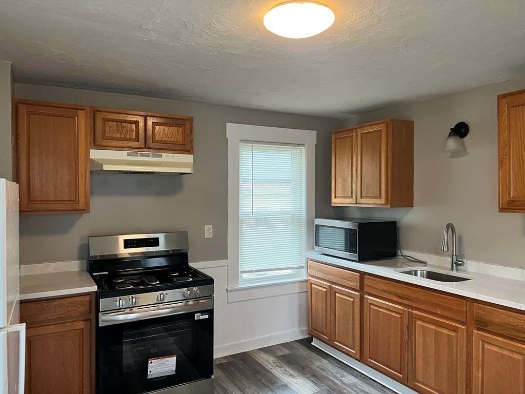 9 Pearl Street, Unit 2 Spencer, MA 01562 - Photo 2 of 12 a kitchen with granite countertop a stove sink and cabinets