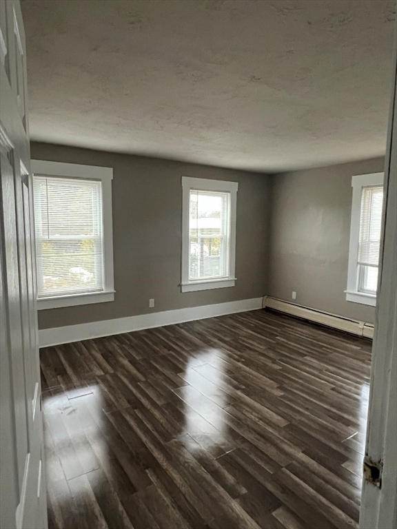 9 Pearl Street, Unit 2 Spencer, MA 01562 - Photo 8 of 12 an empty room with wooden floor and windows