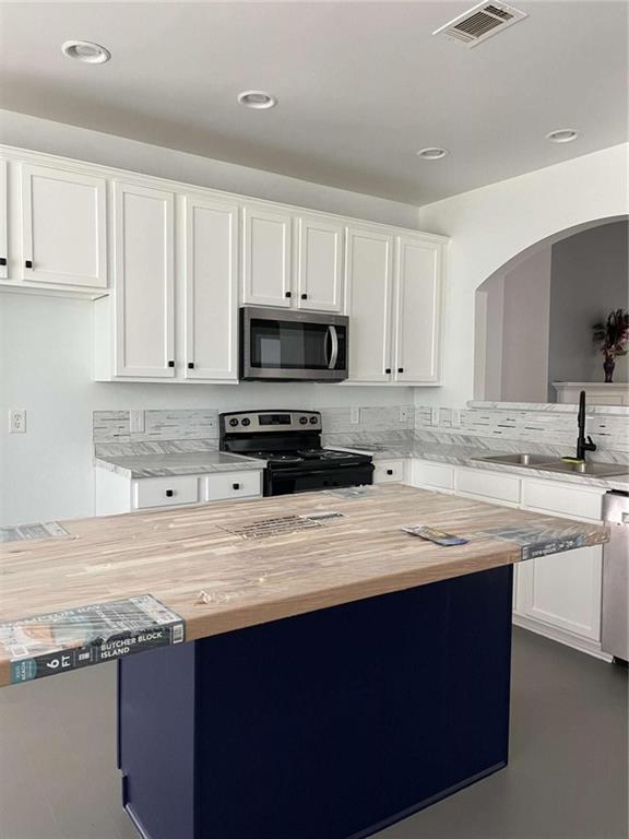 6127 Landers Loop Fairburn, GA 30213 - Photo 6 of 20 a kitchen with stainless steel appliances granite countertop a sink stove and white cabinets