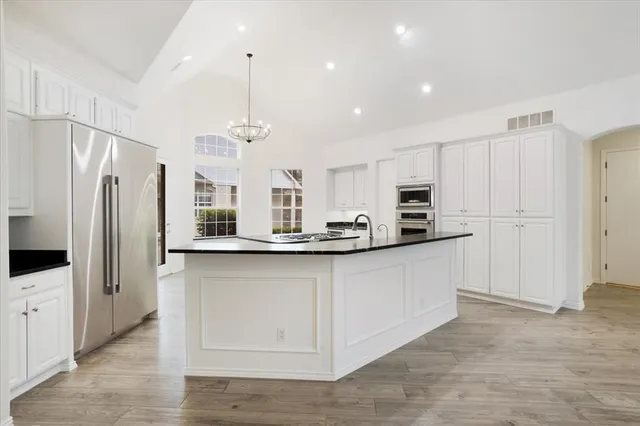 a kitchen with granite countertop a sink stove and cabinets