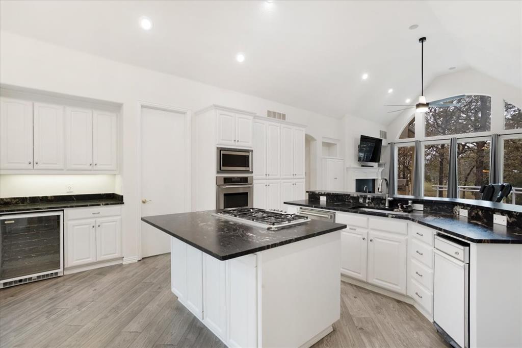 10984 Stagecoach Pass Pilot Point, TX 76258 - Photo 13 of 40 a kitchen with granite countertop a sink stove and cabinets
